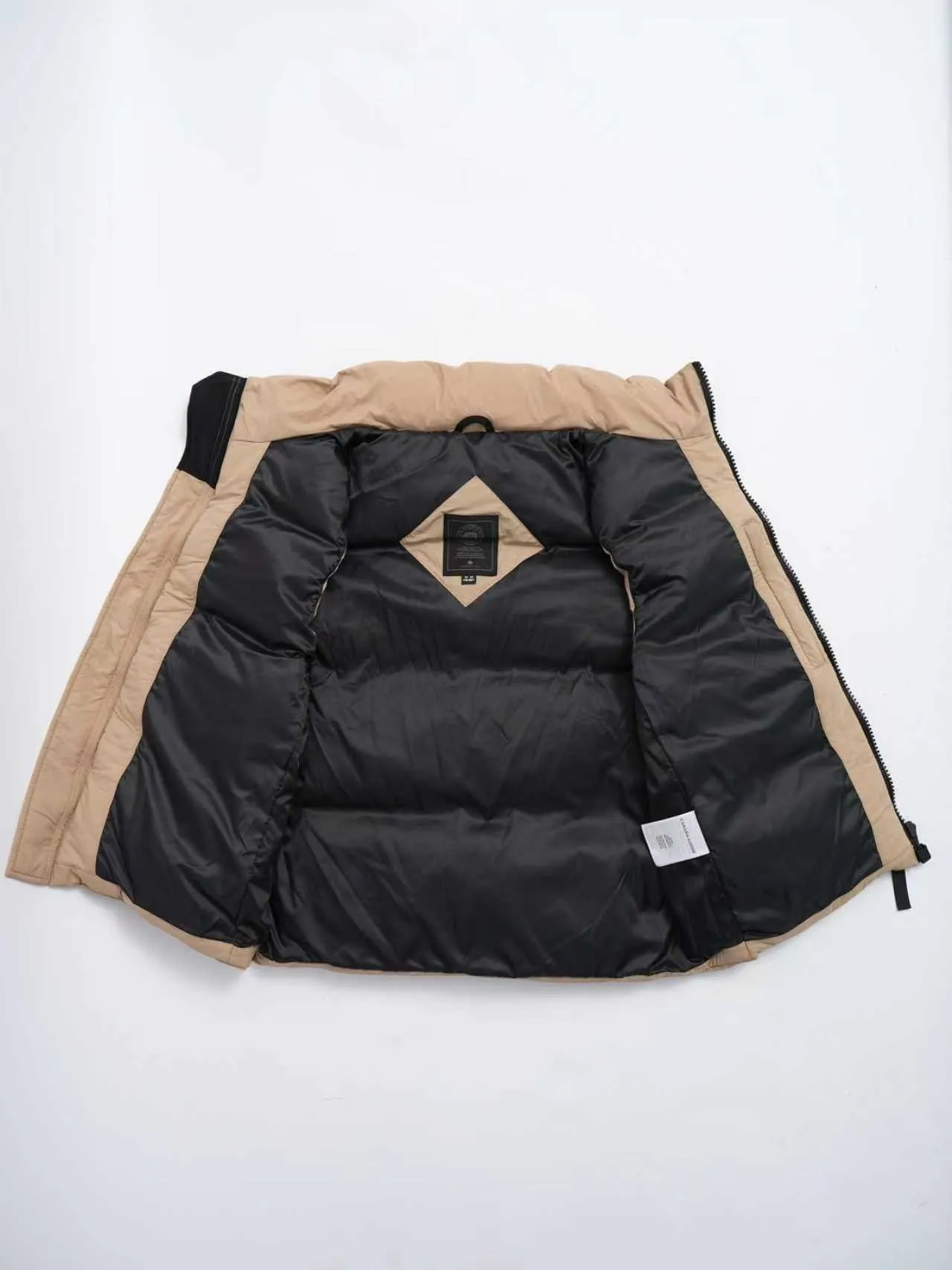 P580 Canada gooes Lawrence Down Vest (high version) With a durable shell and quilted body, the Lawrence Down Vest is a must-have for all seasons. The fabric has a durable soft touch. Longer hem at back for added protection. Reflective double-stripe grip tape at back. The Lawrence features an engineered down-filled collar to block strong winds, a two-way front zip and a longer rear hem. Color: black with red label, black with black label, desert color, ocean blue Size: XS -2XL
